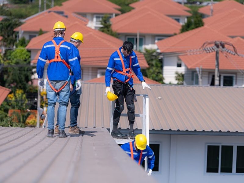After installing and inspecting the performance of the solar cell panels on the factory roof, a group of engineers installing solar panels descends the stairs to go home
