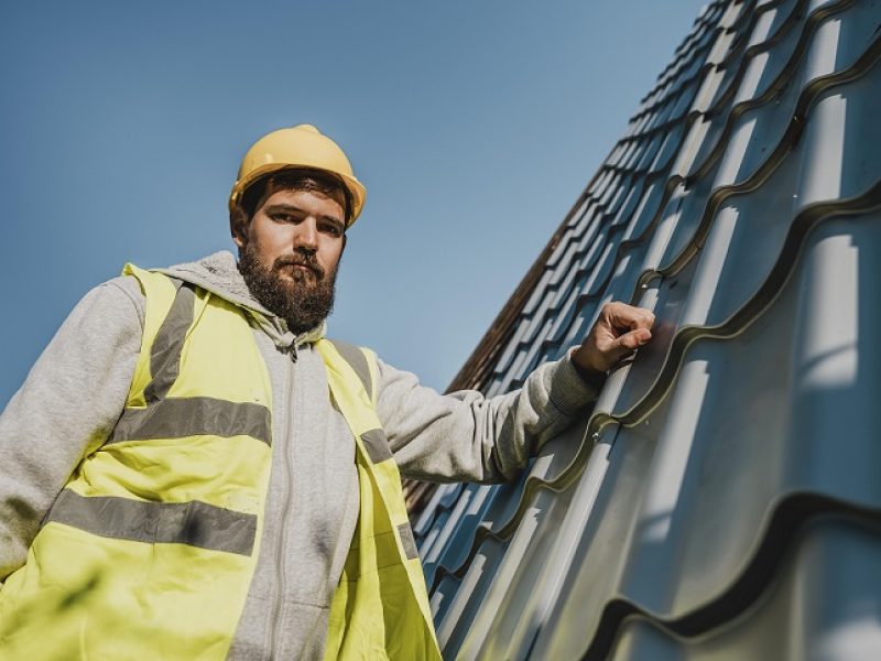 low-view-man-working-roof-with-drill